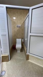 a bathroom with a toilet and two windows at L&K Hostel in Toshkent-Passajir Bekati