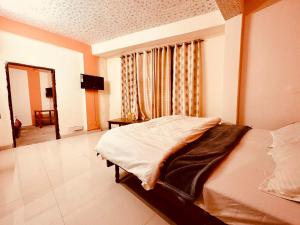 a bedroom with a bed in front of a window at Hotel Giriraj Zirakpur in Chandīgarh +3 photos