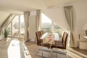a dining room with a table and chairs and a large window at Marbijes Appartementhaus in Cuxhaven