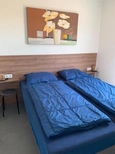 a bed with a blue comforter in a room at Marina Strandbad Chalet Sand & Seele Haus Nr 355 in Olburgen