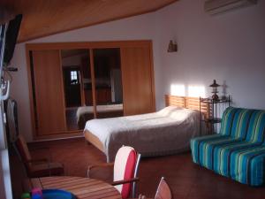 a bedroom with a bed and a couch and a chair at Guest House dos Olivais in Azeitao +10 photos