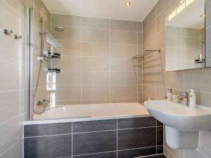 a bathroom with a bath tub and a sink at 4 Bed in Cartmel LCC71 in Cartmel +15 photos