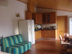 a kitchen with a couch and a white refrigerator at Guest House dos Olivais in Azeitao