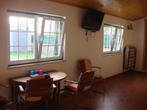a room with a table and chairs and a television at Guest House dos Olivais in Azeitao