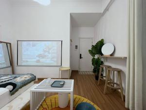 una sala de estar con una cama y una mesa en Sinanli Flower House Courtyard, en Jiazaiwei