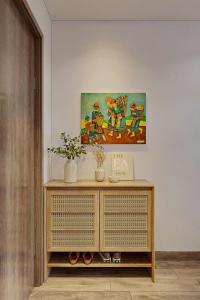 a wooden cabinet in a room with a painting on the wall at H-Vista Panorama Sapa Residences in Sa Pa
