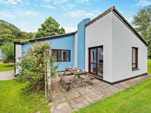 a small blue and white house with a picnic table at 3 Bed in Saltash 30040 in Landrake