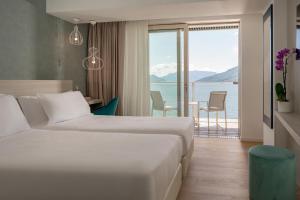 a hotel room with two beds and a view of the water at Hotel Regina in Gravedona +168 photos