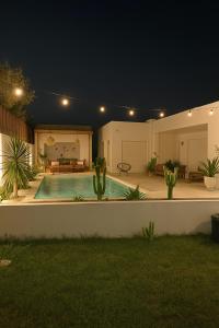 una casa con piscina por la noche en Villa Benbienn piscine iptv Billard américain wifi illimité très bon emplacement, en Taguermess