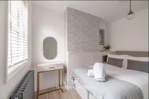 a white bedroom with a bed and a mirror at Modern 2BR - Windsor Stays - Near Castle & Eton - Contractors & Families in Windsor