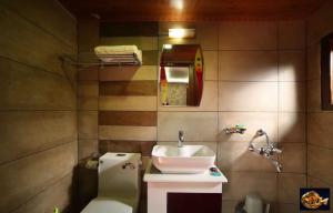 un baño con lavabo e inodoro en Karimeen Boathouse, en Alleppey