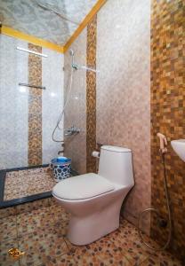 un baño con inodoro y ducha en Karimeen Boathouse, en Alleppey
