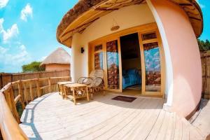 a patio with a table and chairs on a deck at Muhazi Flowers Beach & Resorts in Rwamagana