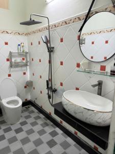 a bathroom with a sink and a toilet and a mirror at TH Homestay in Da Nang