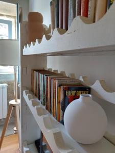 a book shelf with books and a vase on it at Quinta da Coutada - AgroTurismo in Arcos de Valdevez