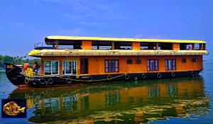 Un barco está sentado en el agua en el agua en Karimeen Boathouse, en Alleppey