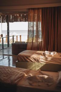 two beds in a room with a view of the ocean at The Wind Farm in Dahab