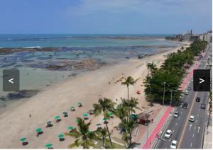 an aerial view of a beach with umbrellas at Apartamento em Maceio, uma quadra da praia in Maceió