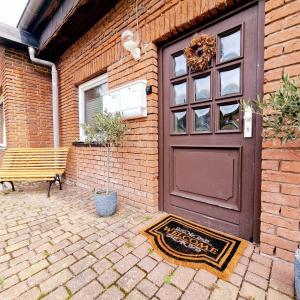 a brown door of a brick building with a bench at Holle - Land Holidays, parterre Ferienwohnung in Lichtenau