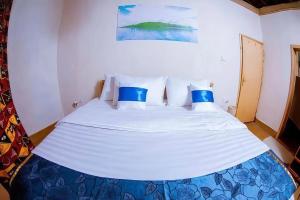 a bed with blue and white pillows in a room at Muhazi Flowers Beach & Resorts in Rwamagana
