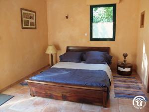a bedroom with a bed with blue sheets and a window at A la fermette de Limesle in La Douaire
