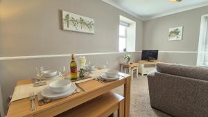 ein Wohnzimmer mit Tisch und Couch in der Unterkunft Sunrise Cottage in Llanddulas