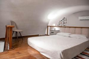 a bedroom with a white bed and a chair at Kladomita in Mestá