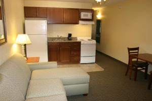 Una sala de estar con un sofá y una cocina. en Affordable Suites of America Augusta, en Augusta 17 fotos más