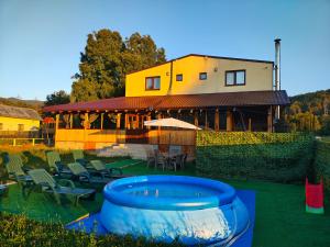 a house with a blue tub in the yard at CASUTA La Amy in Pangarati