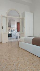 a white bedroom with a bed and a kitchen at Vivi in una Torre Medioevale appartamento in Perugia