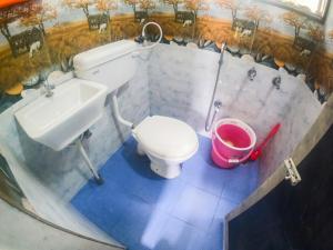 y baño con aseo, lavamanos y cubo. en Kavitha nest, en Yercaud