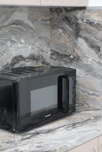 a black microwave sitting on top of a counter at Chios Cozy Apartment 2 in Sklaviá