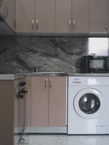 a kitchen with a washing machine and a microwave at Chios Cozy Apartment 2 in Sklaviá +24 photos