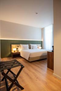 a bedroom with a bed and a chair in it at The Lince Braga in Braga +46 photos