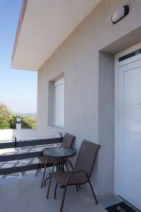 a balcony with chairs and a table and a window at Chios Cozy Apartment 2 in Sklaviá