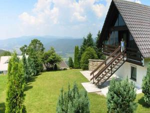 a person standing on the balcony of a house at Ferienhaus im Bayerischen Wald in Schöfweg