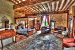 a bedroom with a bed and a desk and a couch at Château De Blavou Normandie in Saint-Denis-sur-Huisne