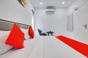 a bedroom with red and white pillows on a bed at Hotel O Sky White House in Ludhiana