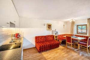 a kitchen and living room with a couch and a table at Unterlacherhof Ahrntal in San Giacomo