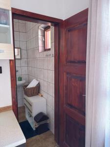 a bathroom with a wooden door and a sink at 2- posteľová izba s kúpeľňou a kuchynkou RIŠKO v PENZION TRSTENÁ in Trstená