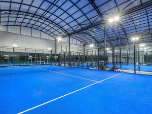 a tennis court with lights in a building at Novotel Setubal in Setúbal
