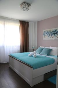 a bedroom with a bed with blue sheets and a window at Joop Apartment in Zagreb