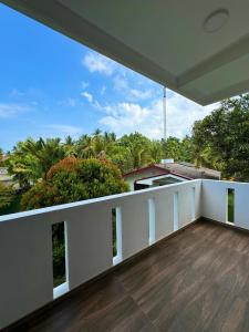 an empty balcony with a view of the trees at Niyanca Guest in Beruwala