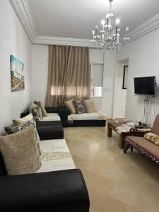 a living room with two couches and a chandelier at Lovely 1-bedroom rental unit with sea view 2 in Mahdia