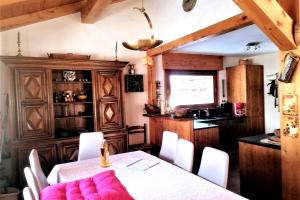 a dining room with a table and white chairs at Le chalet de Julbert in Combloux
