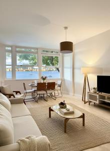 een woonkamer met een witte bank en een tafel bij Apartamento à Beira-Mar na Urca in Rio de Janeiro