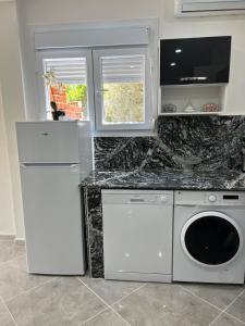 a kitchen with a refrigerator and a washer and dryer at Le Petit Olivier in Mostaganem
