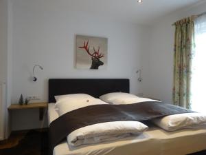 een slaapkamer met een bed met een hertenkop aan de muur bij Pension Rosenhof in Brixen im Thale