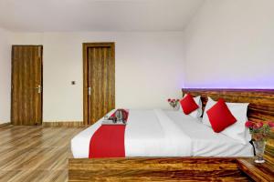 ein Schlafzimmer mit einem großen Bett mit roten Kissen in der Unterkunft Hotel O Times Square in Indraprast
