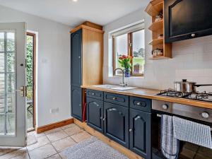 a kitchen with black cabinets and a sink at 1 Bed in Abergavenny BN092 in Llanvetherine +20 photos